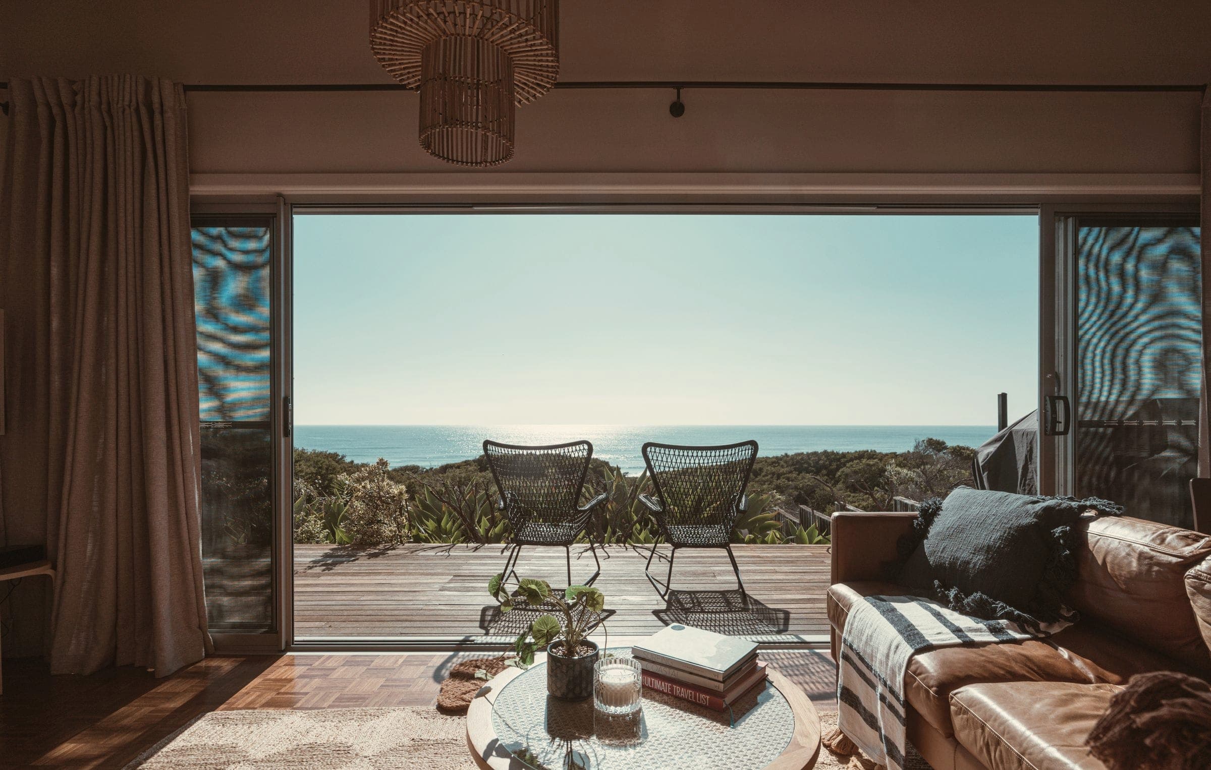Open terrace doors with two chairs looking out over the sea